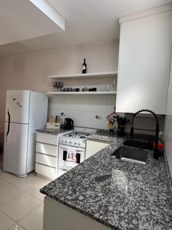 a kitchen with a white refrigerator and a counter top at corazón de Maipú in Maipú