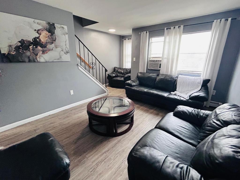 een woonkamer met een leren bank en een tafel bij So sweet so stylish in Elizabeth