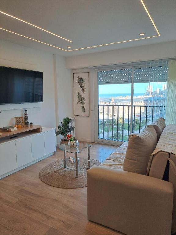 a living room with a couch and a flat screen tv at Vista y confort - Cerca de todo in Mar del Plata