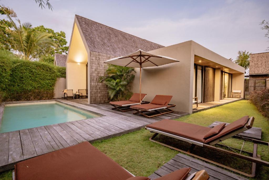a backyard with a swimming pool and a house at Usawa Villa Nyanyi in Munggu
