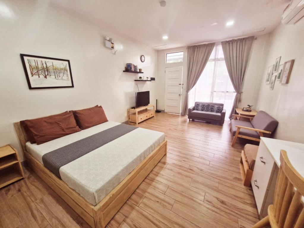 a bedroom with a bed and a living room at CAP Apartments in Talibon