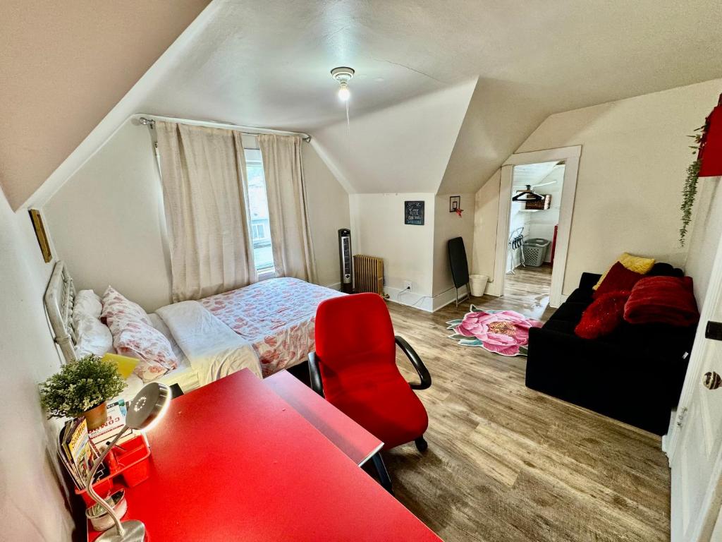 a bedroom with a bed and a red chair at Private Room with Shared Amenities 10 Minutes to Airport and Walking Distance to Bus Station in Seattle