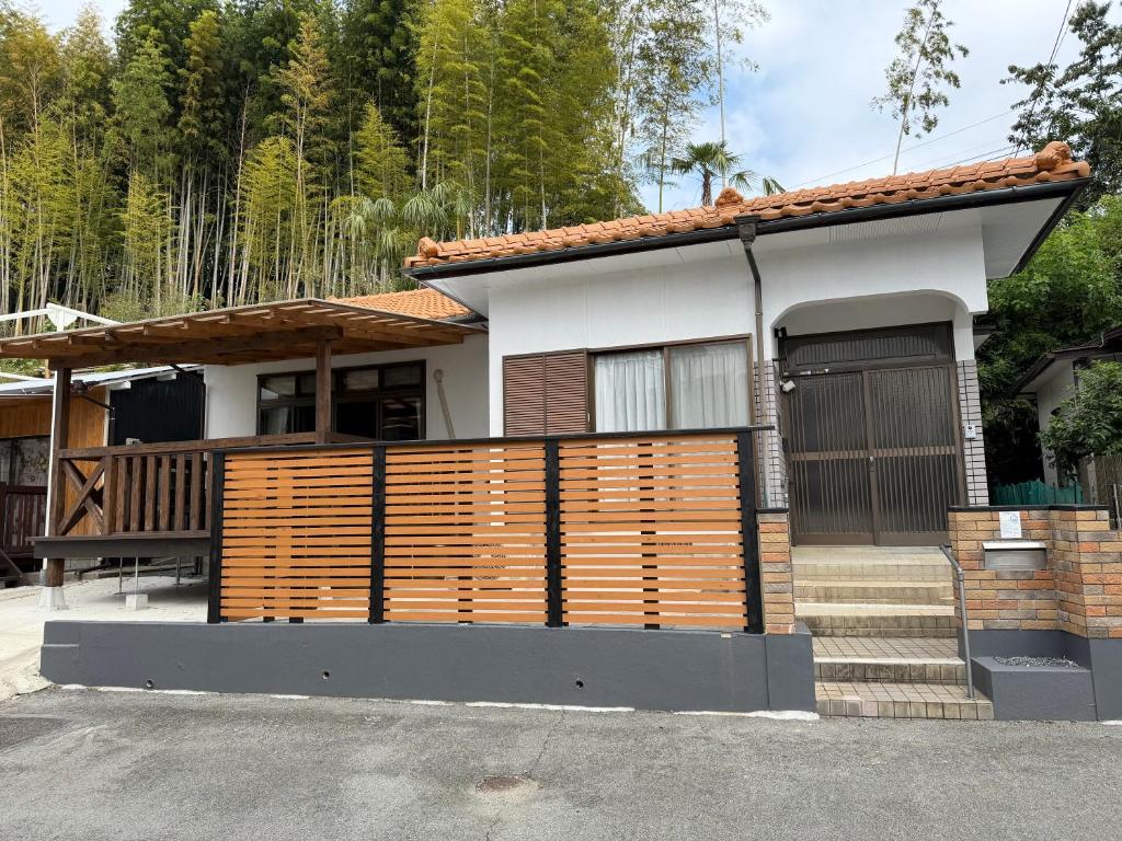 ein Haus mit einem Holzzaun davor in der Unterkunft かみくまハウス in Kumamoto