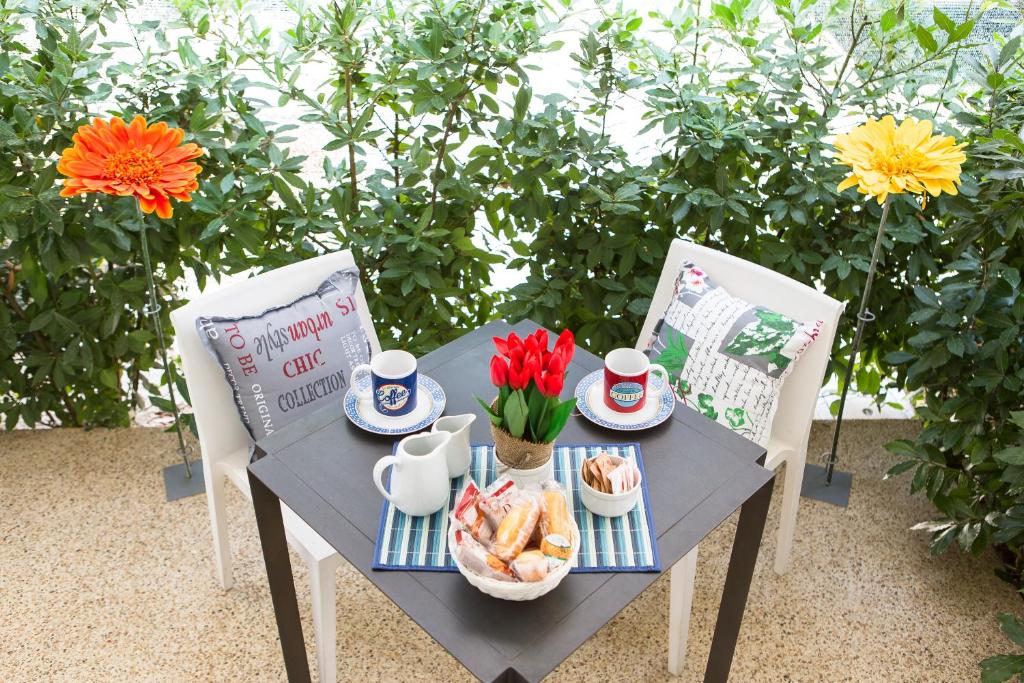 una mesa con una bandeja de comida y flores. en Guest House del Conte en Fondi