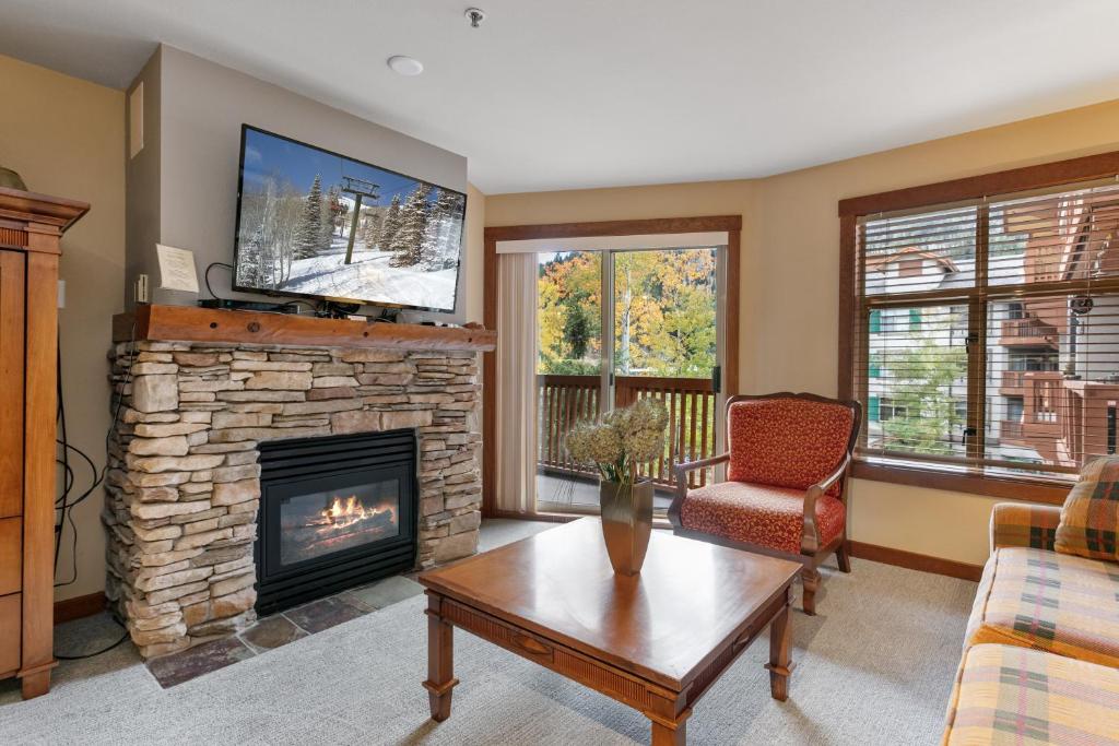 a living room with a fireplace and a tv at 3309 - Two Bedroom Standard Powderhorn Lodge condo in Solitude