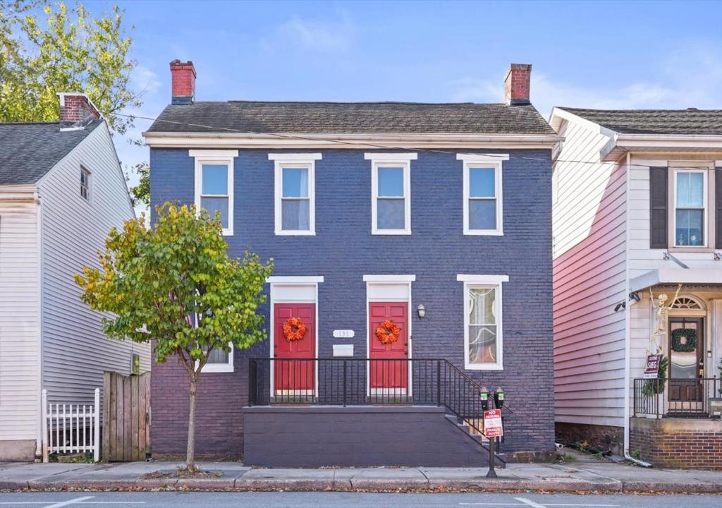 a blue house with red doors on a street at Historic Downtown Gettysburg Gem in Gettysburg