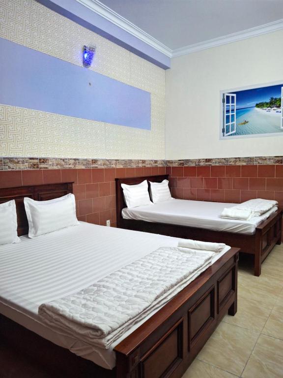 zwei Betten in einem Zimmer mit zwei Betten sidx sidx sidx sidx in der Unterkunft Minh Hồng Hotel in Ho-Chi-Minh-Stadt