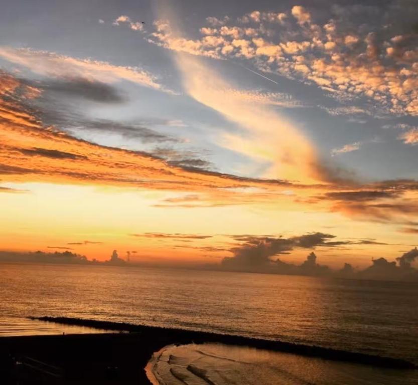 einen Sonnenuntergang über dem Meer mit wolkigem Himmel in der Unterkunft El Dago in Cartagena de Indias