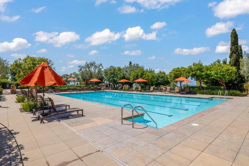 a pool at a resort with an orange umbrella at @ Marbella Lane - 4BR Mediterranean-style Home in Newport Beach