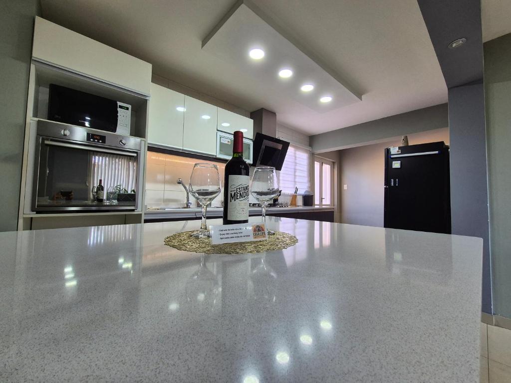 a bottle of wine sitting on a counter in a kitchen at Casa Lupe - Con Piscina Climatizada in Las Heras