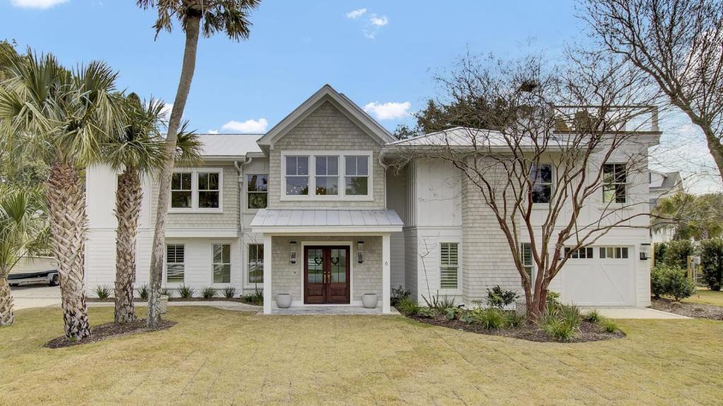 a white house with palm trees in front of it at 6 36th Avenue by AvantStay Stunning Private Pool in Isle of Palms