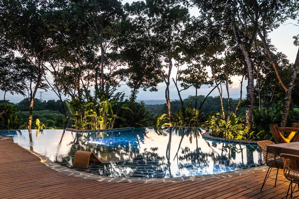 a swimming pool with a table and chairs and trees at Hotel Boutique Maitta en Doradal Antioquia in Doradal