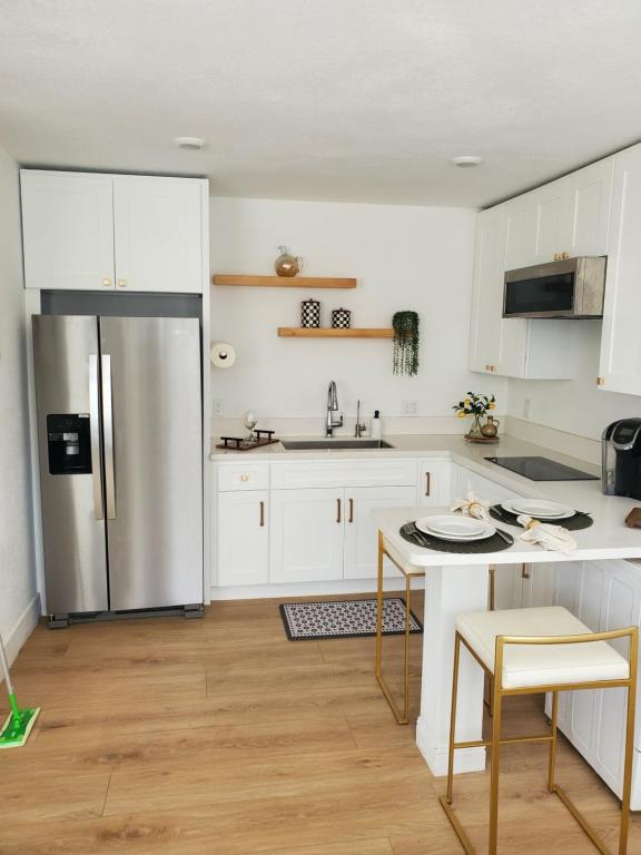 uma cozinha com armários brancos e uma geladeira de aço inoxidável em Comfortable Luxury Studio em Northridge