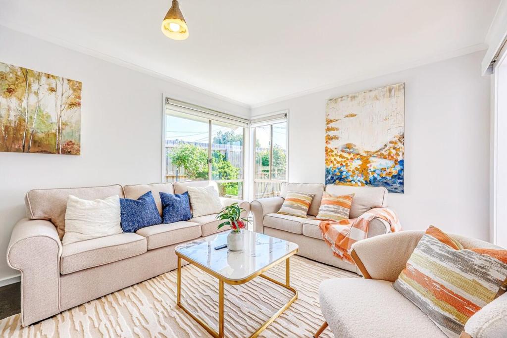 a living room with a couch and a table at StayAU 4BR Family-Friendly Home near Deakin Uni in Whittington