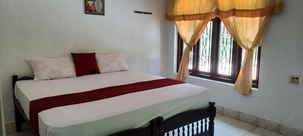 a bed in a room with a window at Kalanja Greens Nilagiri Villa in Ooty