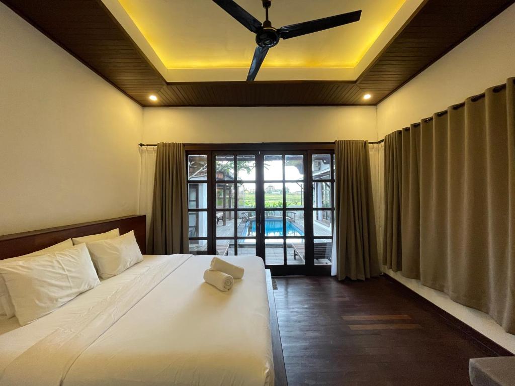 CemagiVilla Kayu Sungkai的带床和吊扇的卧室