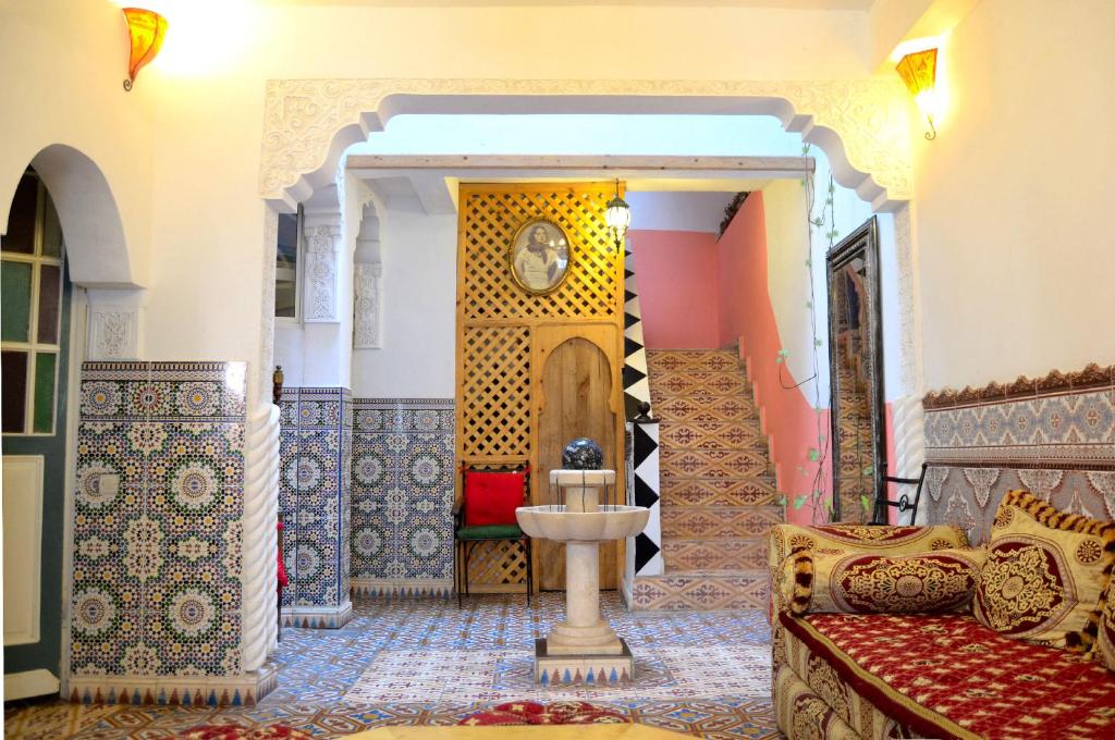 une chambre avec un canapé et un réveil sur le mur dans l'établissement Maison d'hôtes Cité Portugaise, à El Jadida