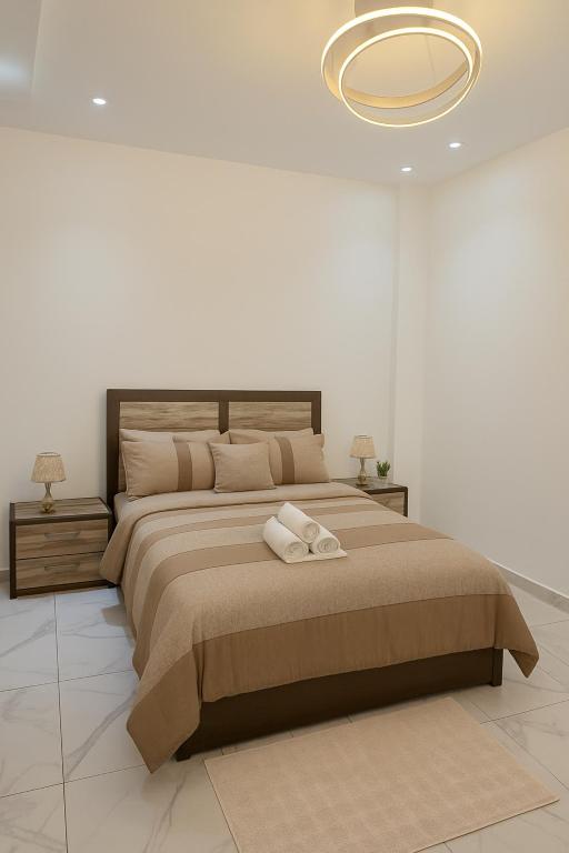 达喀尔Residence ACN 2B的一间卧室，有一张大床，床上有两条毛巾