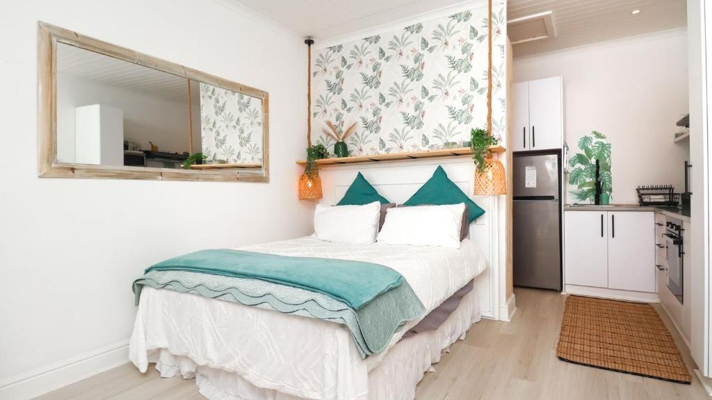 Un dormitorio con una cama con un espejo en la pared. en Dune Sanctuary, en Plettenberg Bay