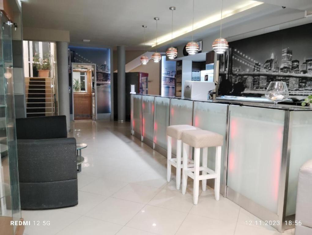 a restaurant with a bar with stools and a kitchen at Apartaments Diva in Varna City