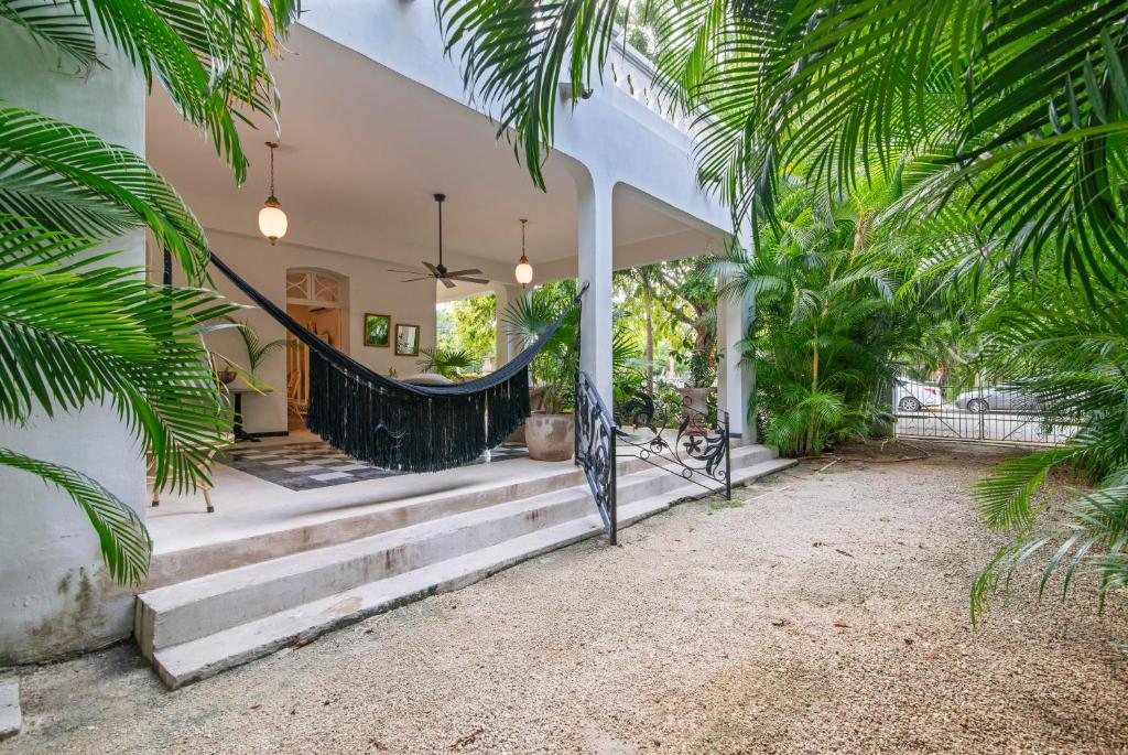 a house with palm trees and a staircase at Casa Damiana, Colonial Charm with Private Pool in Mérida