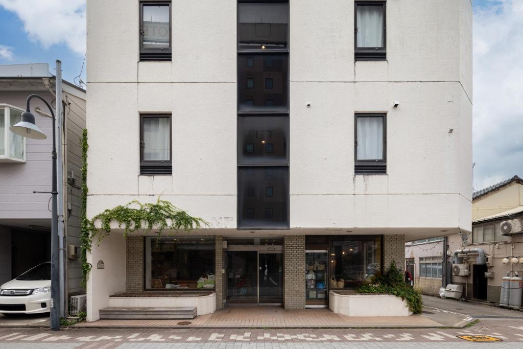 a white building on a city street at Crasco TABI-NE in Kanazawa