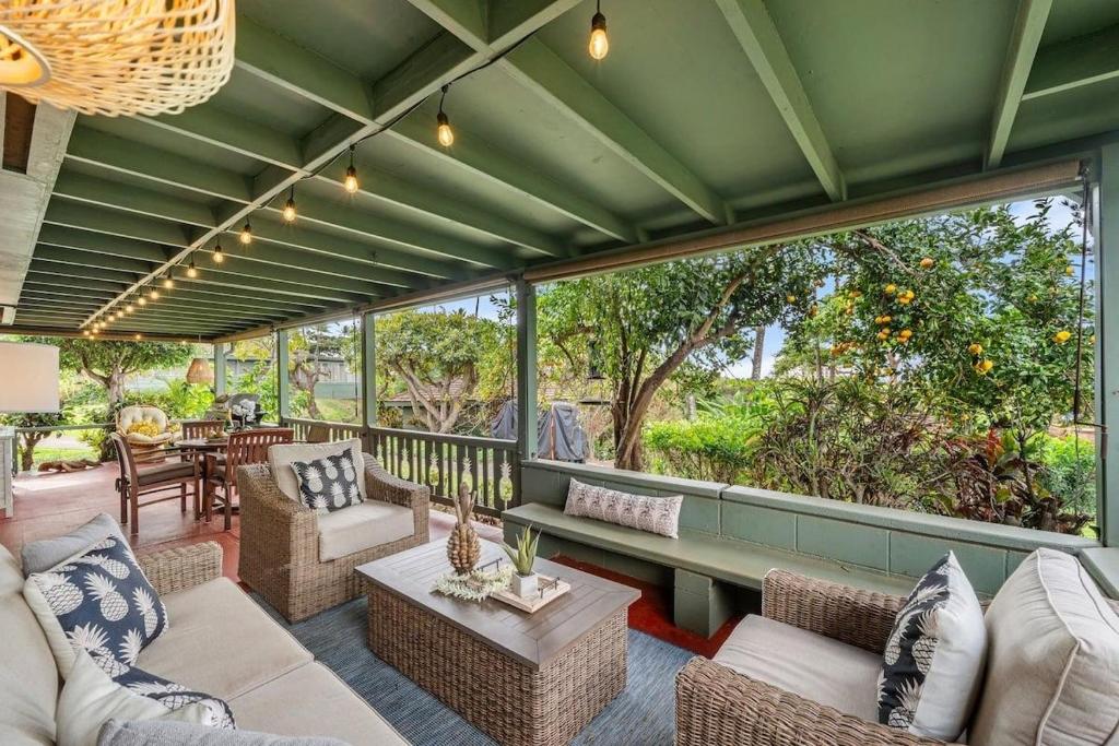 an outdoor patio with couches and tables and windows at International Colony Club 28 · ICC 28 Remodeled 2BD Cottage in K in Lahaina
