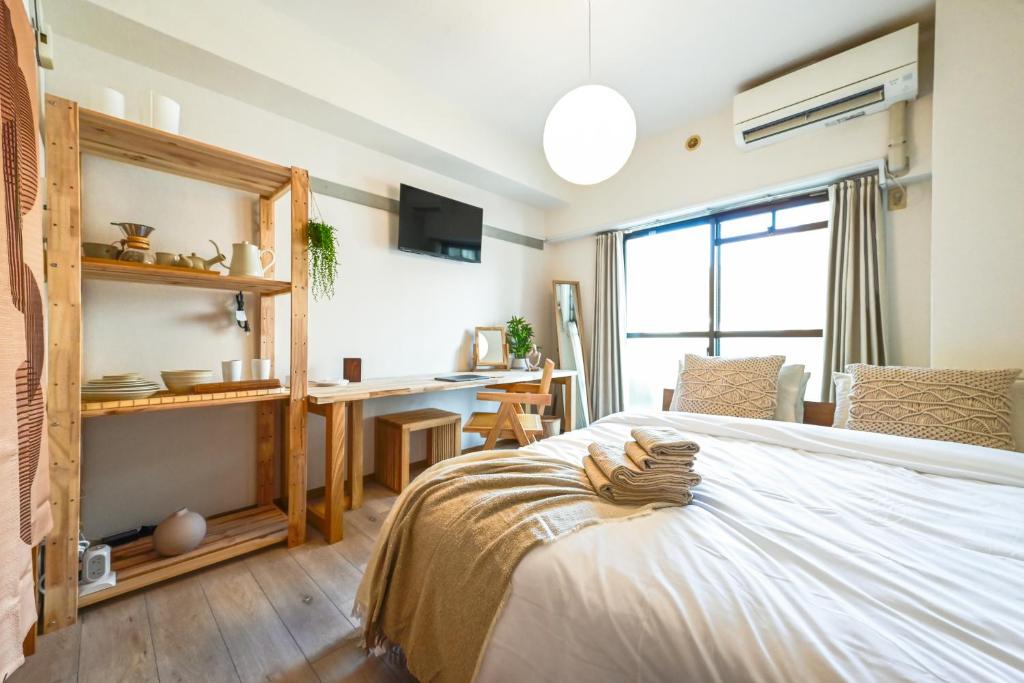 a bedroom with a bed and a desk in a room at Japandi 6 Inspired 1BR in Prime City Spot and Near Station in Fukuoka