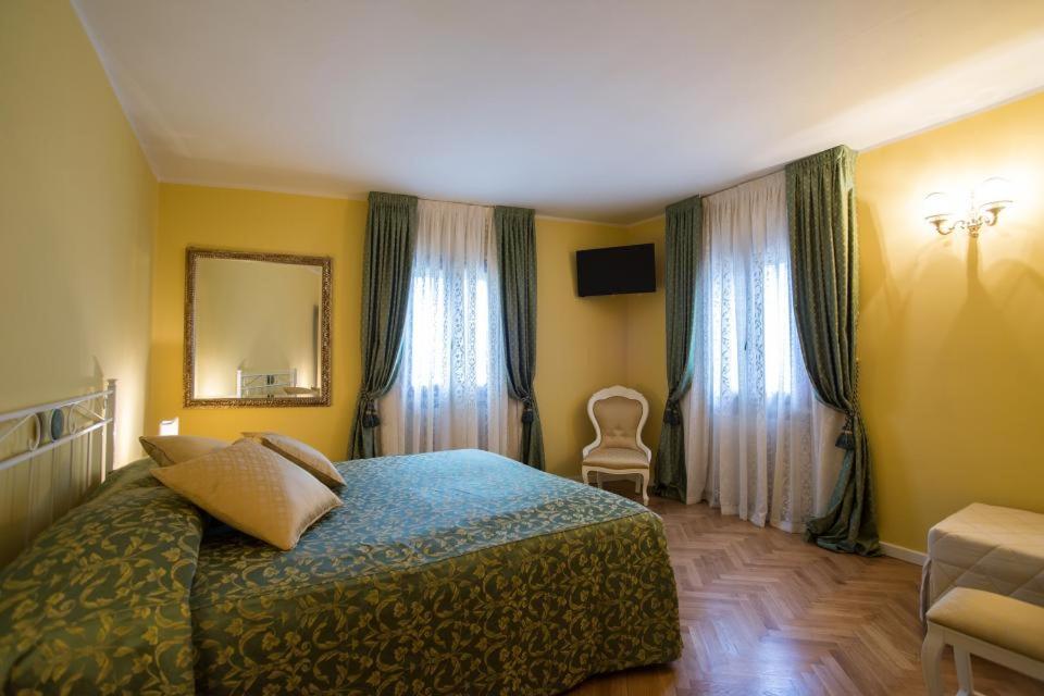 sypialnia z łóżkiem, krzesłem i oknami w obiekcie B&B La Pescadora w mieście Valeggio sul Mincio
