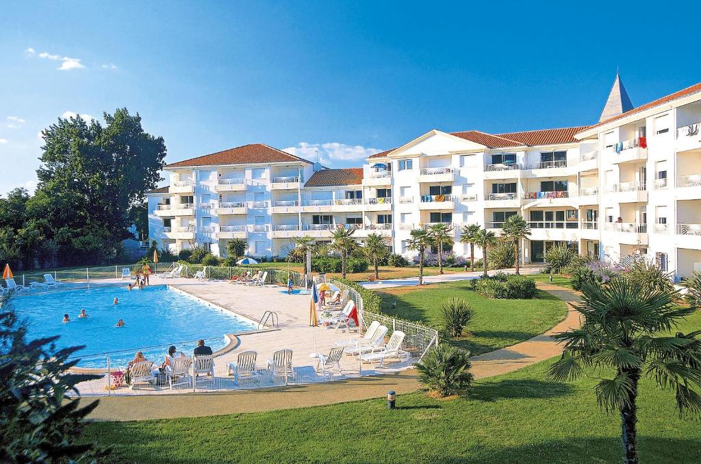 a resort with a swimming pool and a large building at Résidence Odalys Thalassa in Les Sables-d'Olonne