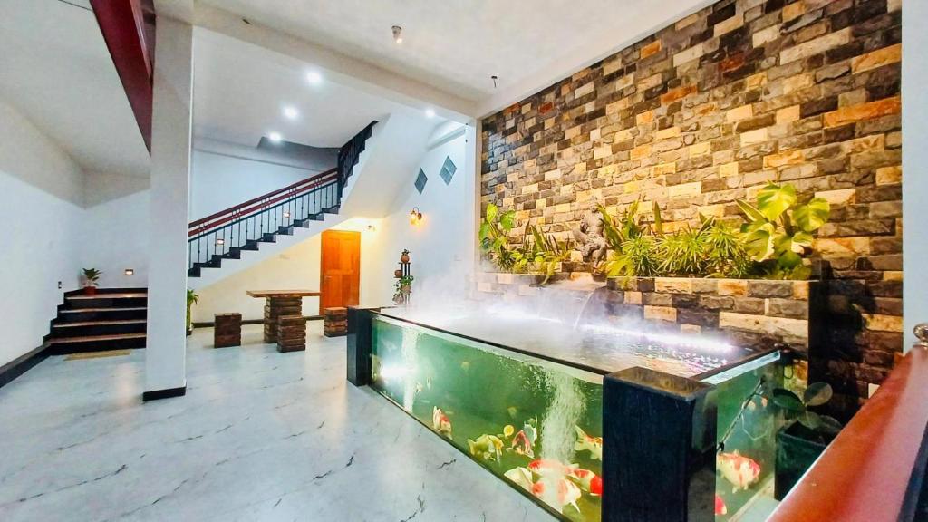 a large aquarium in a room with a brick wall at Elegant Resort Hiriketiya in Dickwella