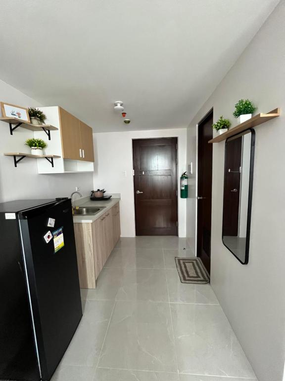 a kitchen with a black refrigerator and a sink at Casa Mira Mandaue unit 608 Tower 4 in Cebu City