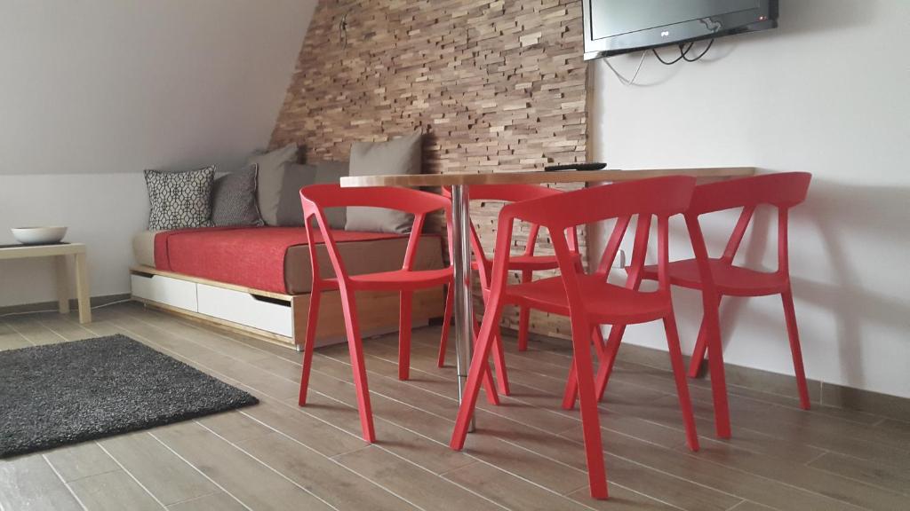 einen roten Tisch und Stühle in einem Zimmer mit einem Bett in der Unterkunft Apartmani Kopaonik Centar Maglic in Kopaonik