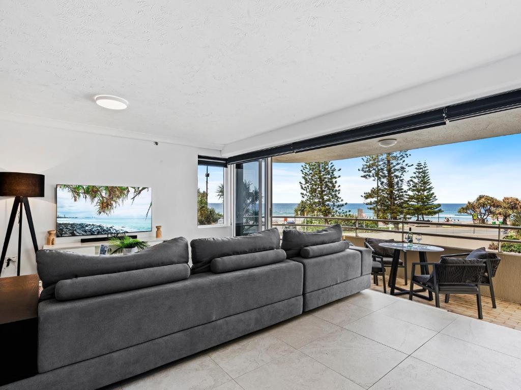 a living room with a couch and a view of the ocean at Beachfront Escape Zenith - Ocean Views, Pool, Spa in Gold Coast