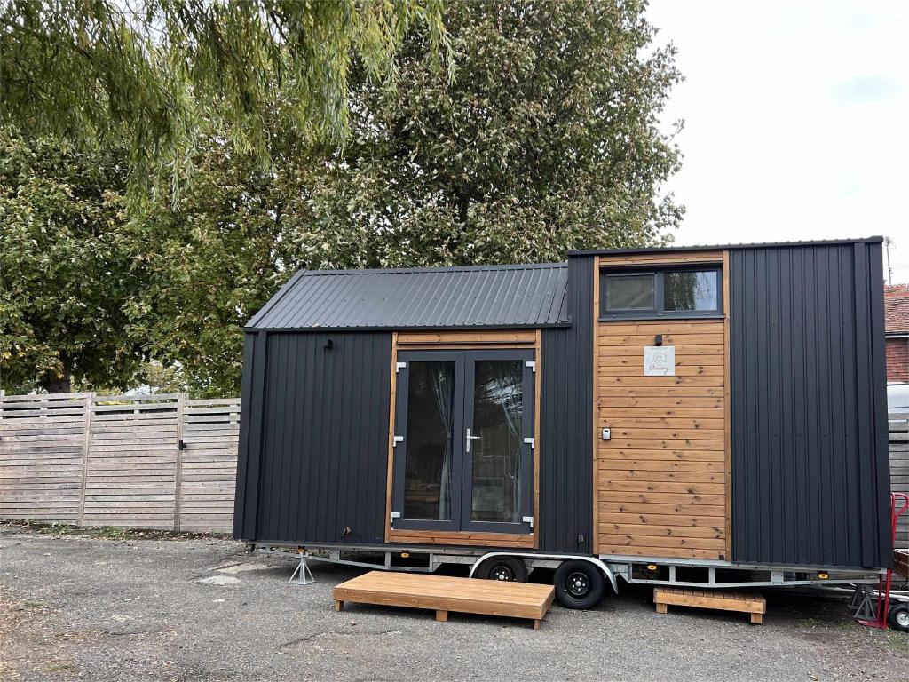 una pequeña casa negra sentada en un estacionamiento en Ridge Hill X by Tiny Away, en Wilmington