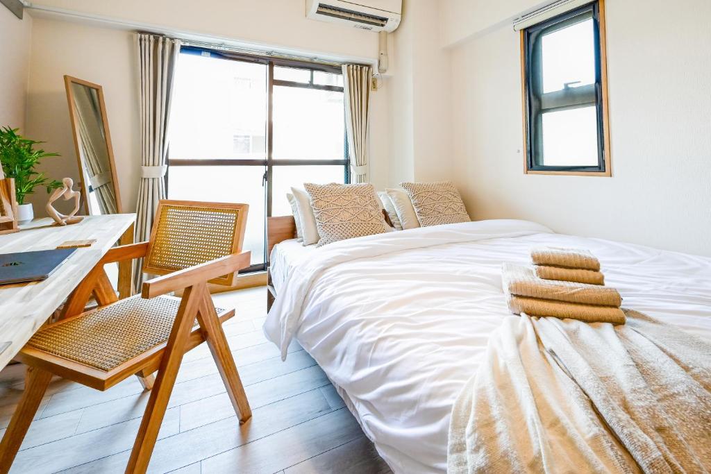 a bedroom with a bed and a desk and a window at Japandi 4 Inspired 1BR in Prime City Spot and Near Station in Fukuoka