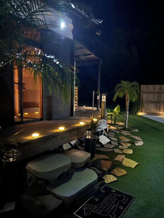a backyard at night with a stone pathway and a house at Village Misaki in Misaki