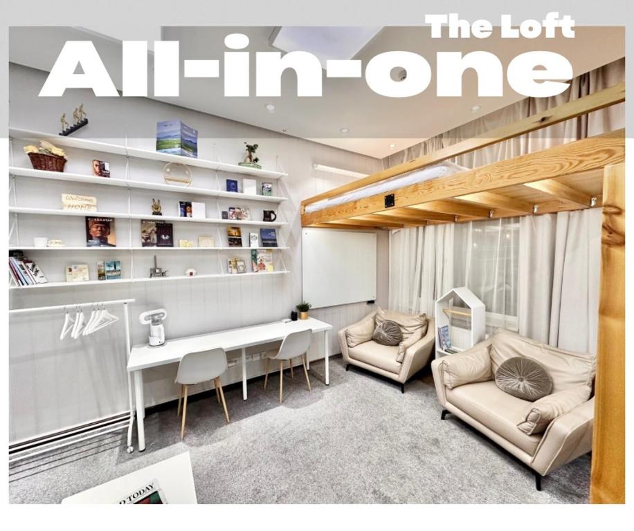 Una imagen de una sala de estar con un escritorio y sillas. en The All-in-One Loft, en Ulán Bator