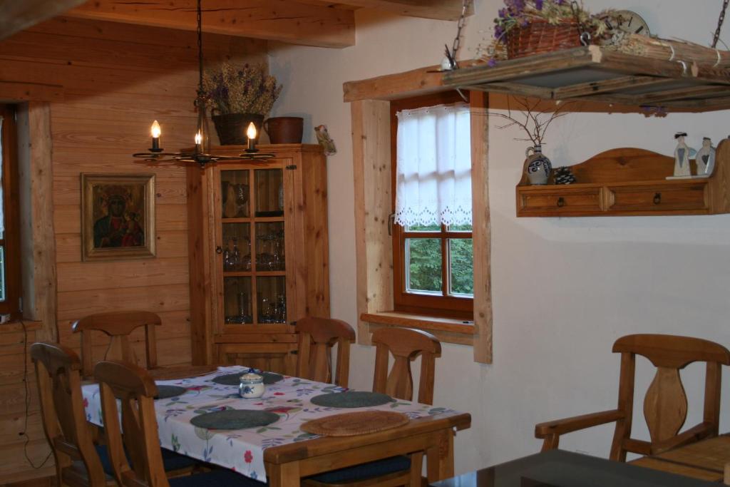 jadalnia ze stołem i kilkoma oknami w obiekcie Dom pod Jesionami w mieście Ochotnica Dolna
