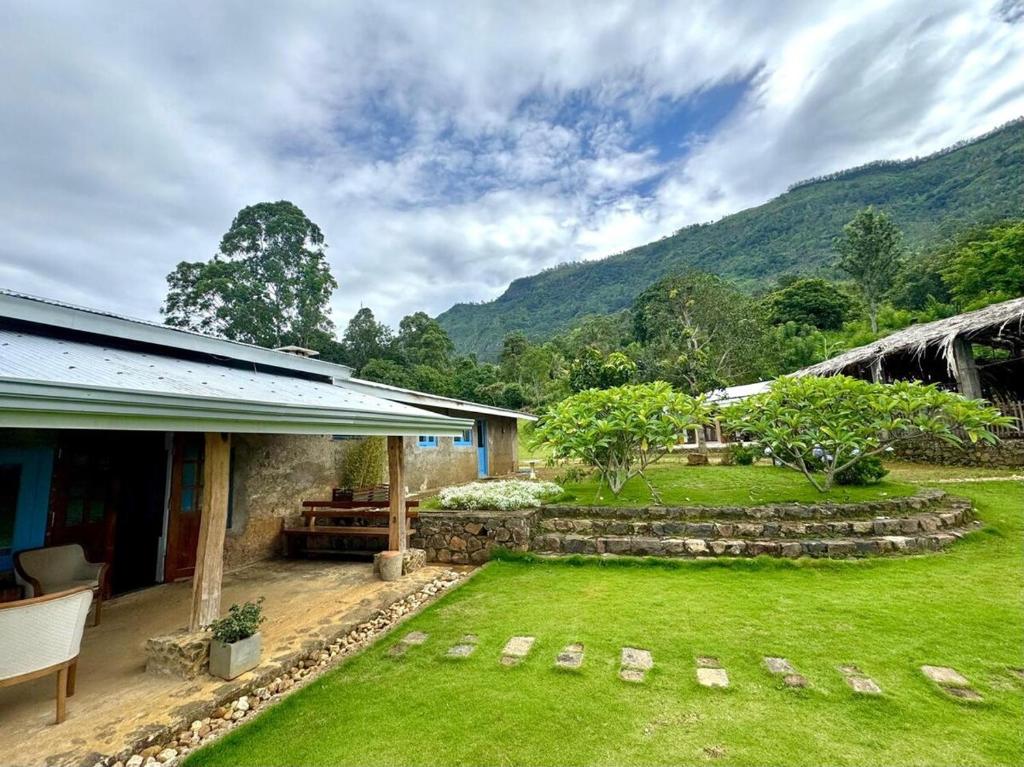 a backyard with a grass yard and a house at Blackwoods Farmhouse in Beragala