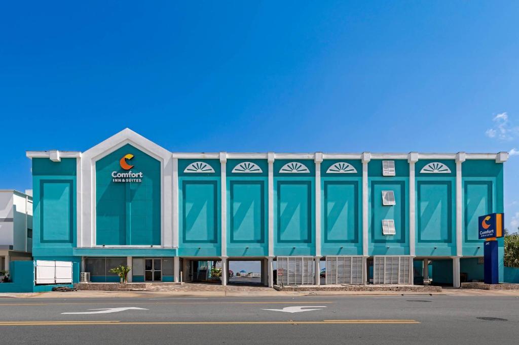 a large blue building with a company sign on it at Comfort Inn & Suites Ormond Beach Oceanfront in Ormond Beach