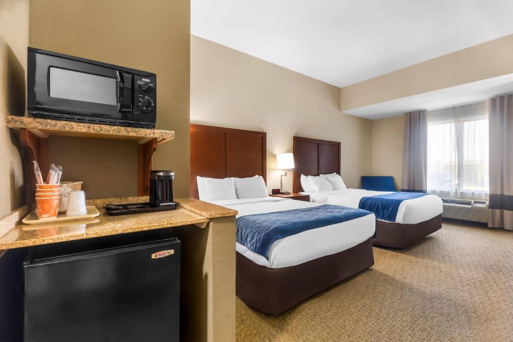 a hotel room with two beds and a flat screen tv at Comfort Inn & Suites Sikeston I-55 in Sikeston