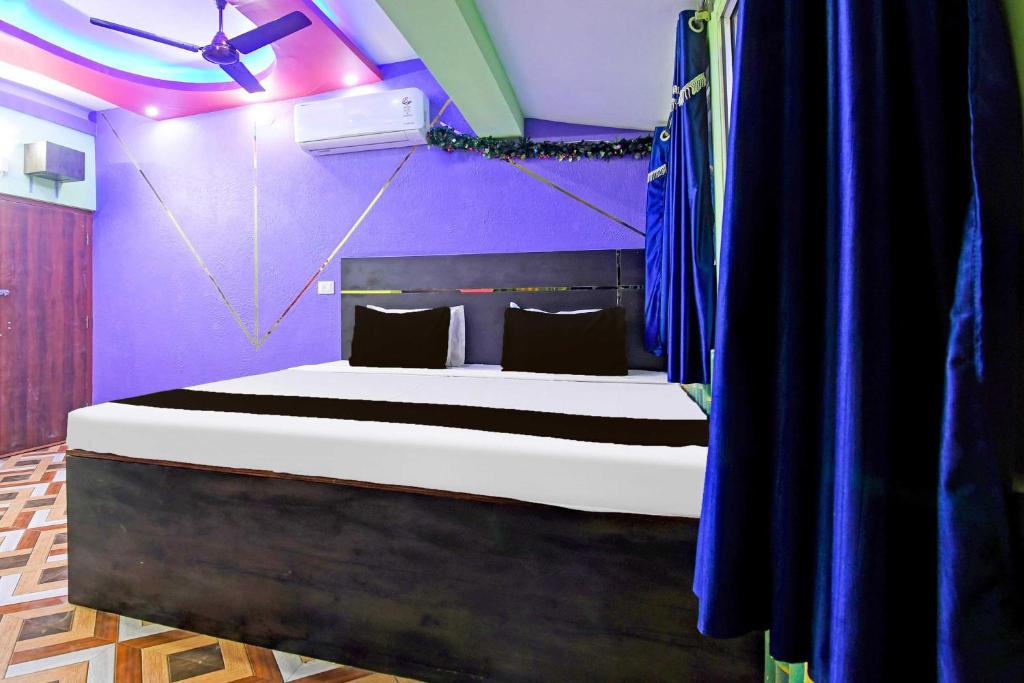 a bedroom with a large bed with purple walls at Hotel O Star Mall Kolkata Formerly Dreamland in Dohāri