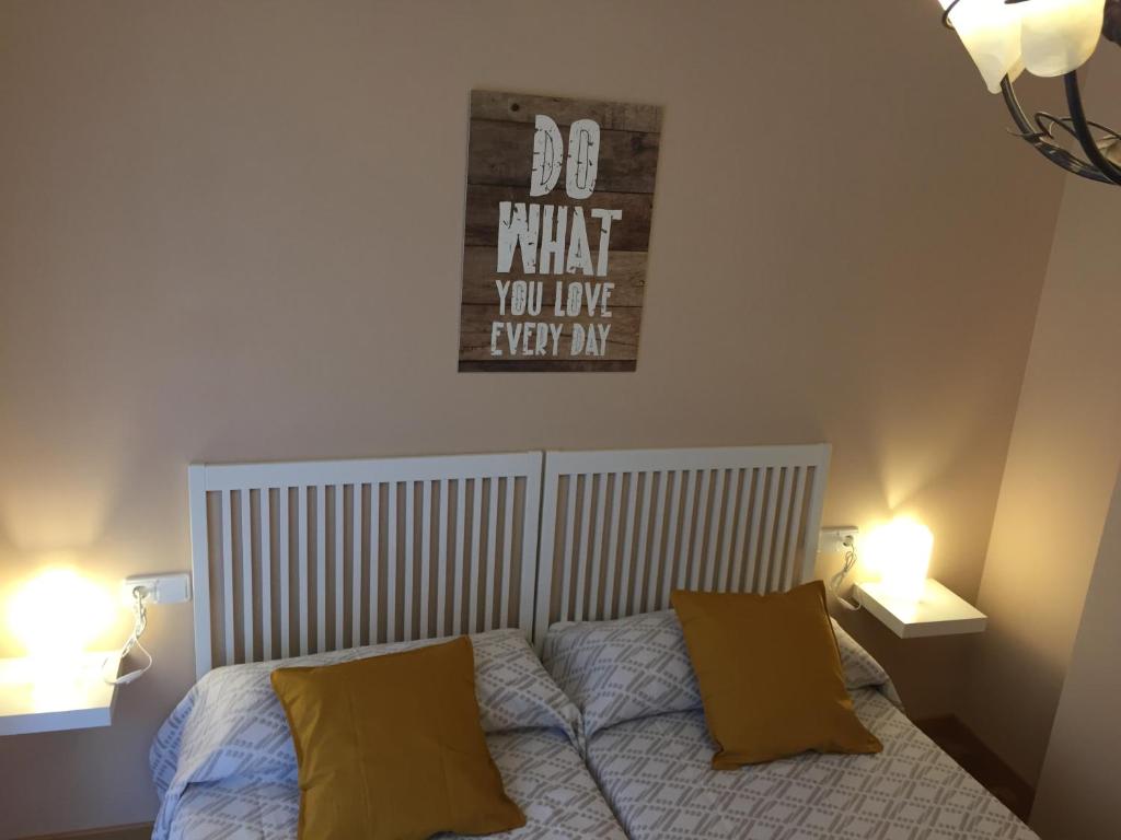 - une chambre avec un lit et 2 oreillers jaunes dans l'établissement Apartamento Peñaguda, à Estella
