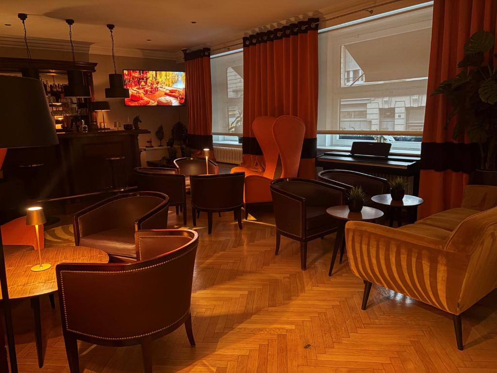 un restaurante con mesas, sillas y un piano en Maison LUTETIA R, en Estrasburgo