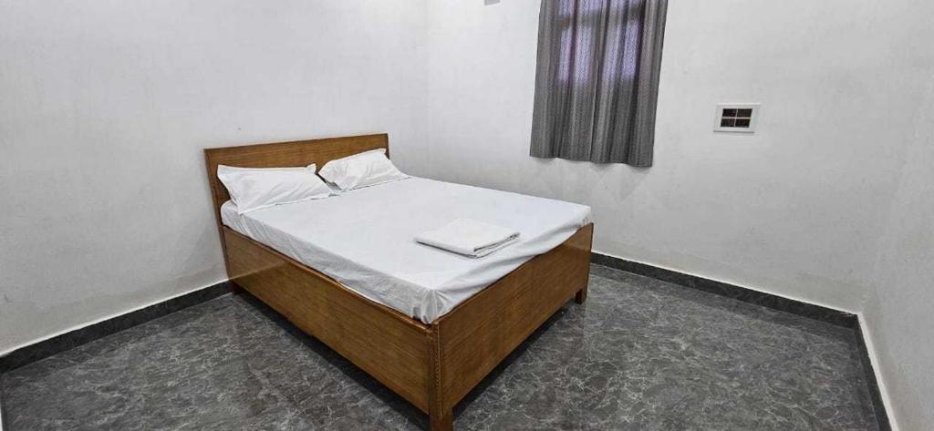 ein Schlafzimmer mit einem Bett mit weißen Laken und einem Fenster in der Unterkunft HOTEL O BABA PREM HOTEL in Bihta