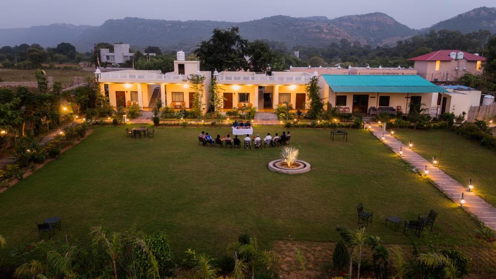 a group of people sitting on a lawn in front of a building at Ranthambhore Ghati in Sawāi Mādhopur