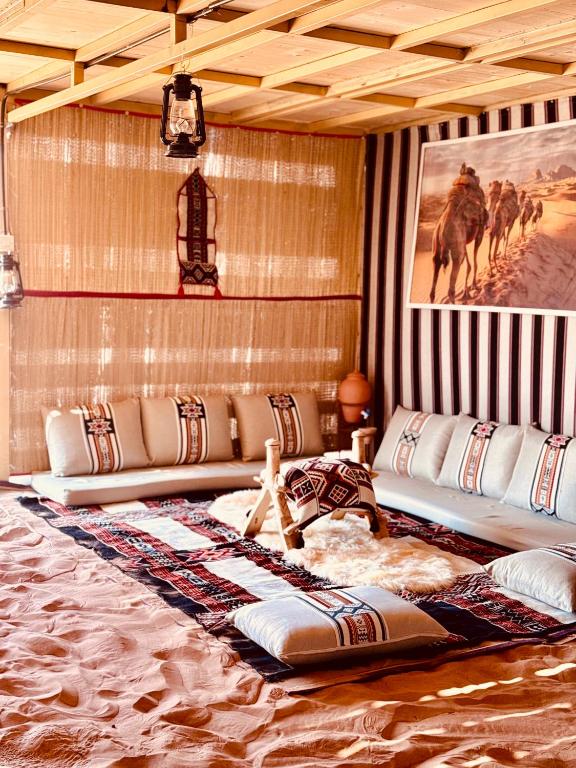 a living room with a couch and a painting on the wall at Desert Vibes Camp in Bidiyah