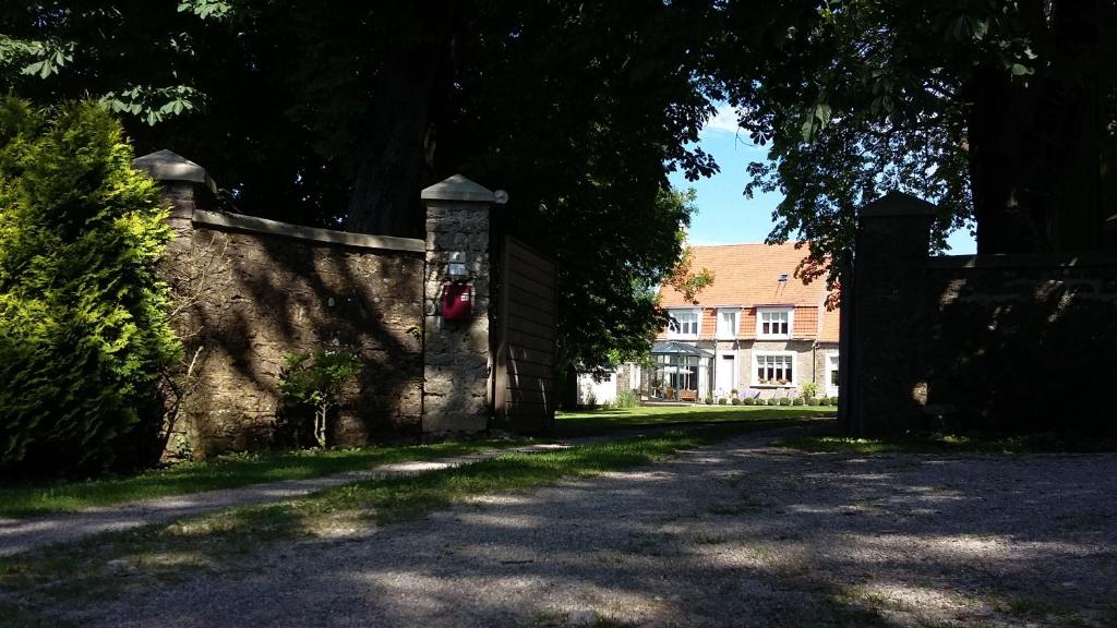 a stone wall with a gate in front of a house at Les Hauts de la Cluse in Wimille