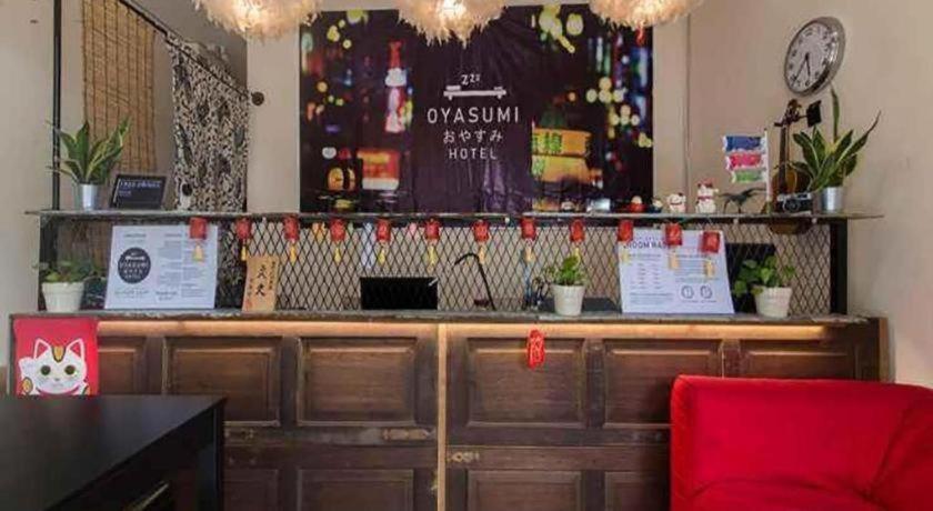 a counter in a restaurant with a red chair at Oyasumi Hotel in Kulim